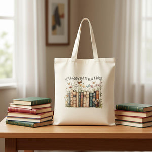 A beige tote bag with a printed design of a row of colorful books surrounded by flowers and butterflies.