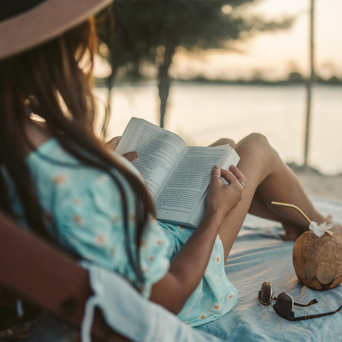 The image is a gift box containing various items related to summer activities, including a book, cookies, sunglasses, and other beach-themed items.
