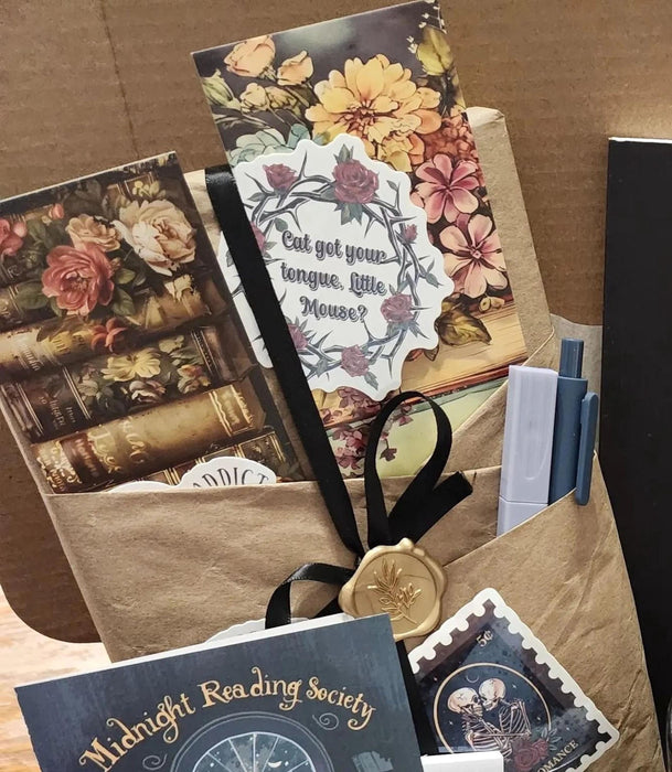 various items related to the "Dark Academia" theme, including a book, a mug, a candle, and other miscellaneous objects.