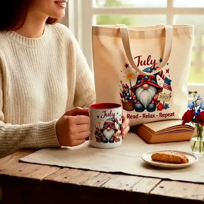 a set of personalized July-themed items, including a tote bag, a tumbler, and a mug, all decorated with illustrations of gnomes and patriotic symbols.