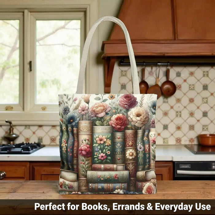 A tote bag with a floral pattern and a mug with a book and flower design, both placed on a stack of books.