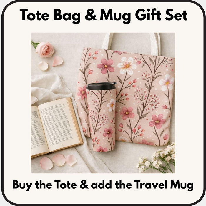A tote bag with a floral pattern and a travel mug are displayed on a table, along with a book and some rose petals.