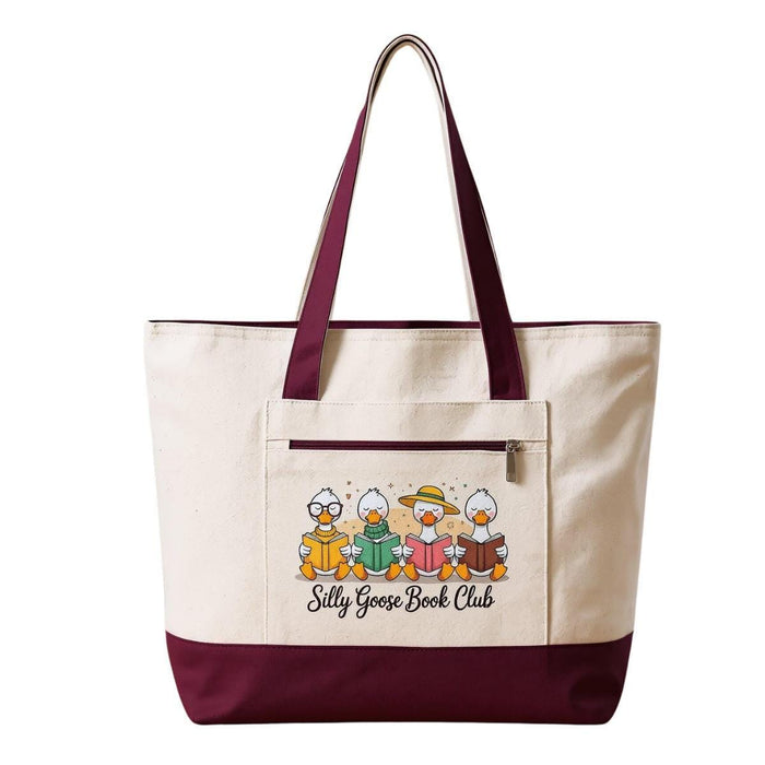 A tote bag and a travel mug with a design featuring cartoon ducks and the text "Silly Goose Book Club" are displayed on a wooden table.