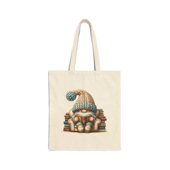a tote bag and a mug with a gnome sitting on a stack of books, both with a knitted hat on.
