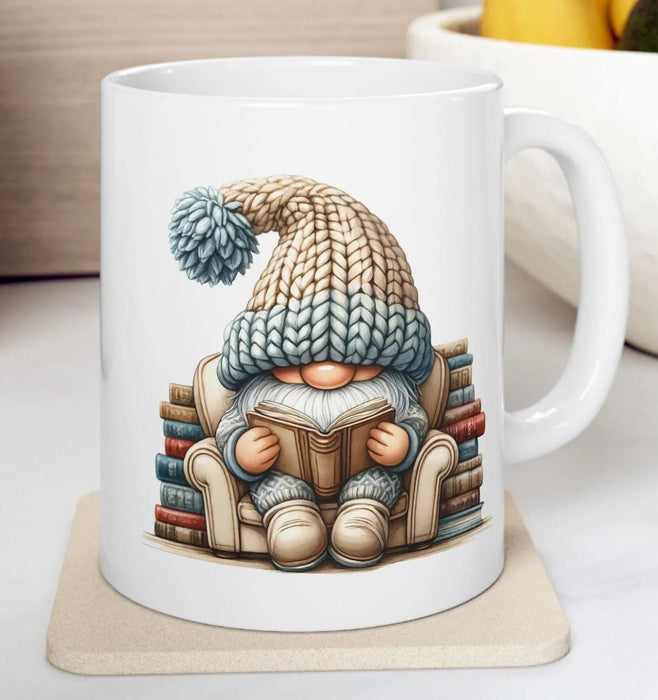 a tote bag and a mug with a gnome sitting on a stack of books, both with a knitted hat on.