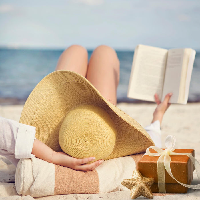 The image is a gift box containing various items related to summer activities, including a book, cookies, sunglasses, and other beach-themed items.