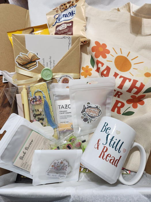 A gift box containing various items related to faith and grace, including a book, a mug, a card, and other small items.