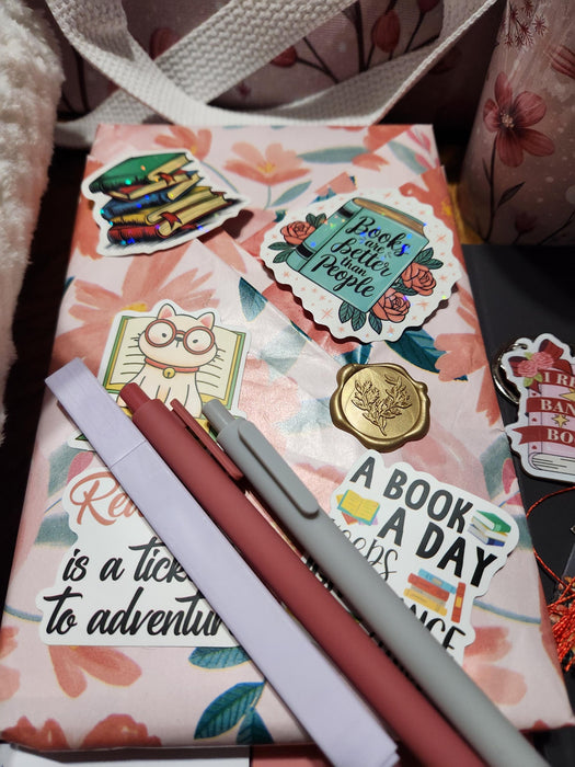 A box containing various items, including a book, snacks, candles, and other miscellaneous items, all wrapped in brown paper and tied with twine.