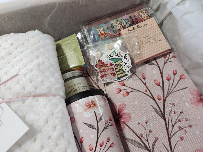 A box containing various items, including a book, snacks, candles, and other miscellaneous items, all wrapped in brown paper and tied with twine.