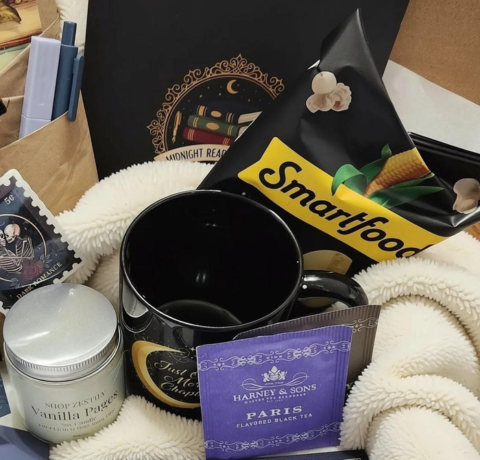 various items related to the "Dark Academia" theme, including a book, a mug, a candle, and other miscellaneous objects.