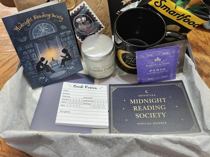 various items related to the "Dark Academia" theme, including a book, a mug, a candle, and other miscellaneous objects.