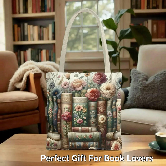 A tote bag with a floral pattern and a mug with a book and flower design, both placed on a stack of books.