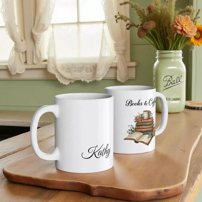 A white tote bag with a printed design of a stack of books and a cup of coffee, placed on a wooden table in a living room setting.
