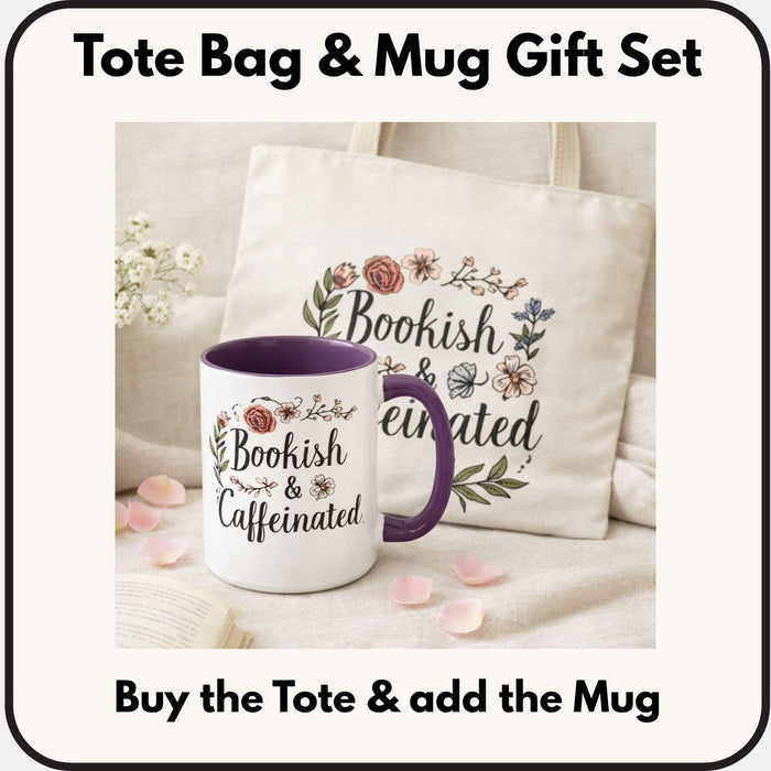 A white tote bag with a floral design and a purple handle, along with a white mug with a floral design and a purple handle, both sitting on a beige surface.