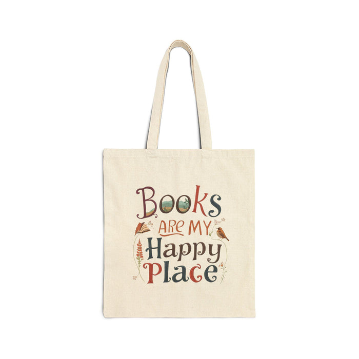 A tote bag and a mug with the text "Books are my Happy Place" printed on them, along with a book and a pen.